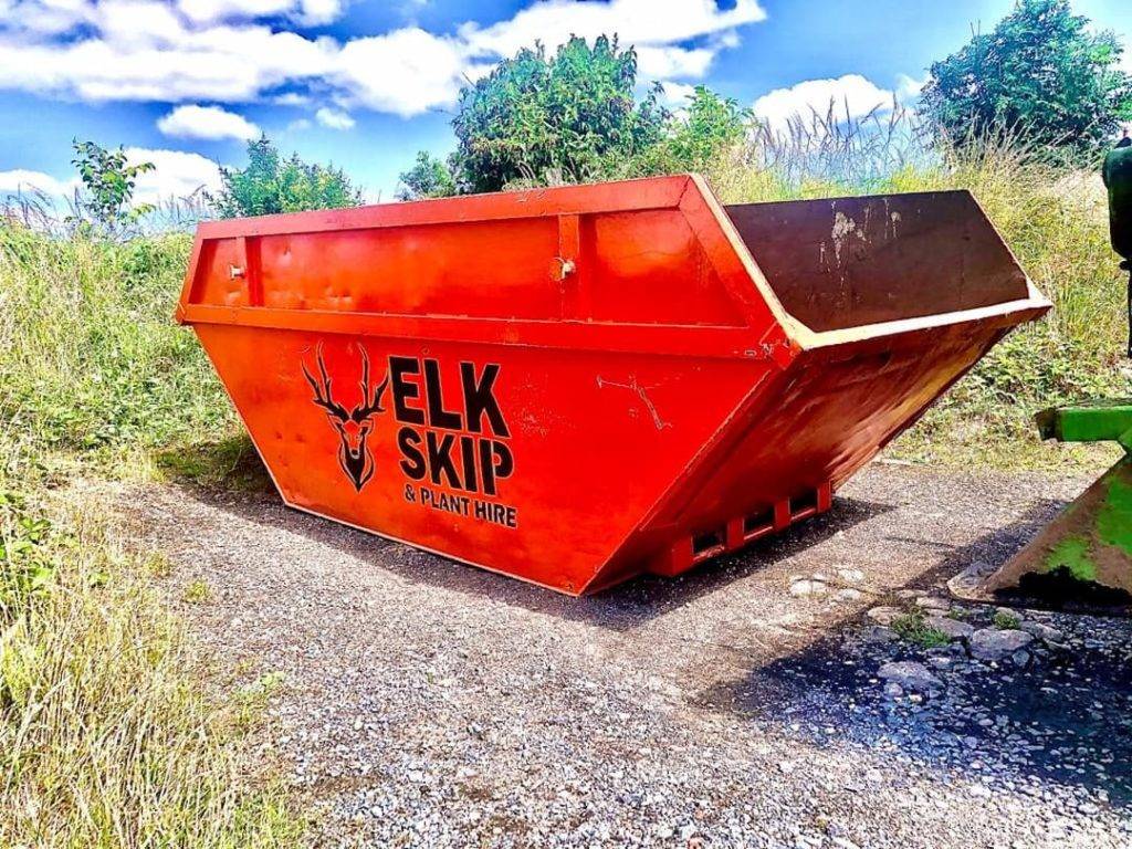 Orange Skip With Elk Skip Hire Logo On The Side