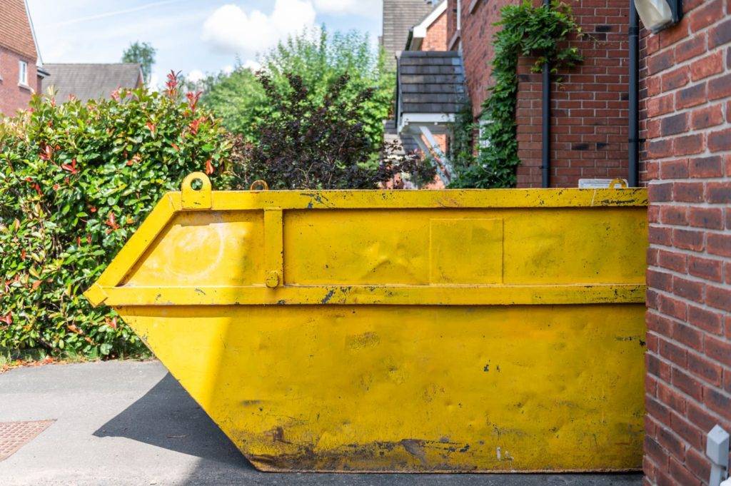 Skip hire. Yellow skip on driveway